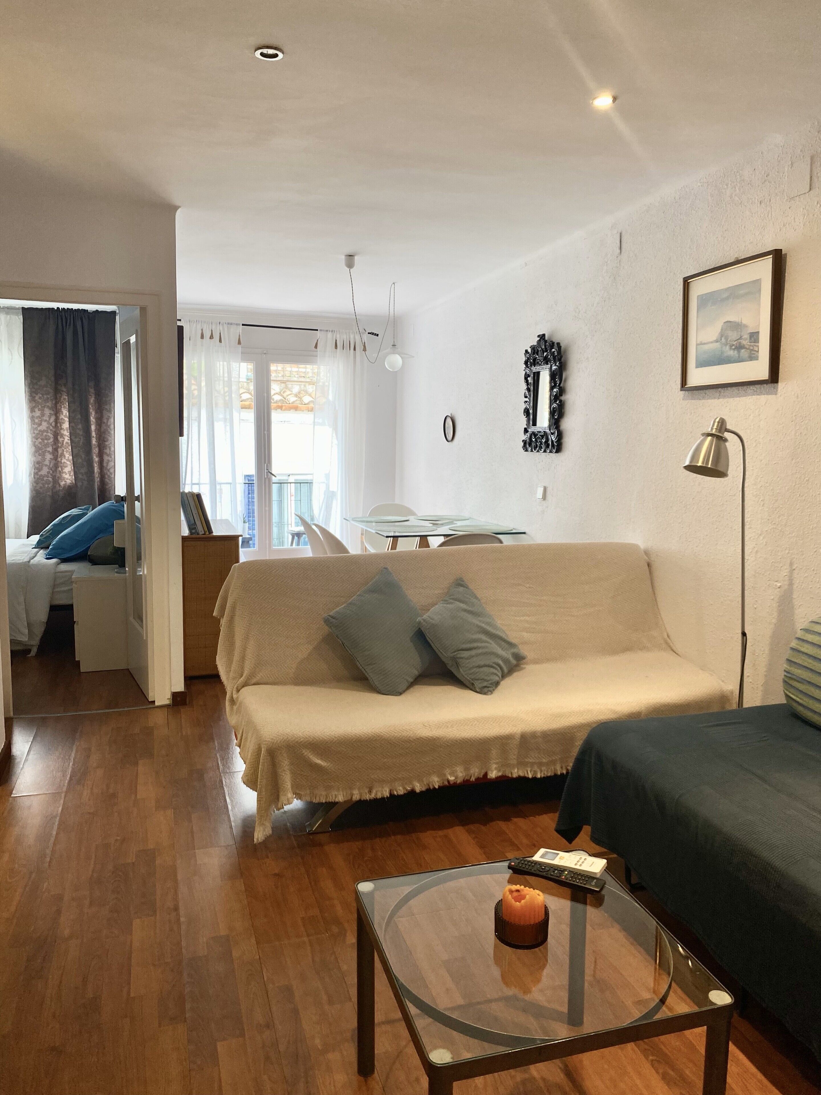 Een woonkamer met een bank, een salontafel en een eethoek met een tafel en stoelen.