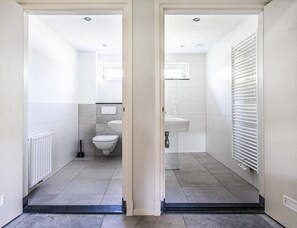 A modern bathroom with a toilet, sink, and radiator. - Koudekerke Coastal Getaway for 7 (Koudekerke)