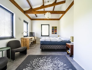 A bedroom with a bed, desk, chair, and a large window. - Koudekerke Coastal Getaway for 7 (Koudekerke)