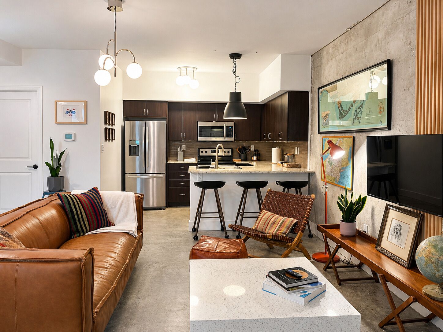 A modern kitchen with dark cabinets, stainless steel appliances, and a bar area with stools.