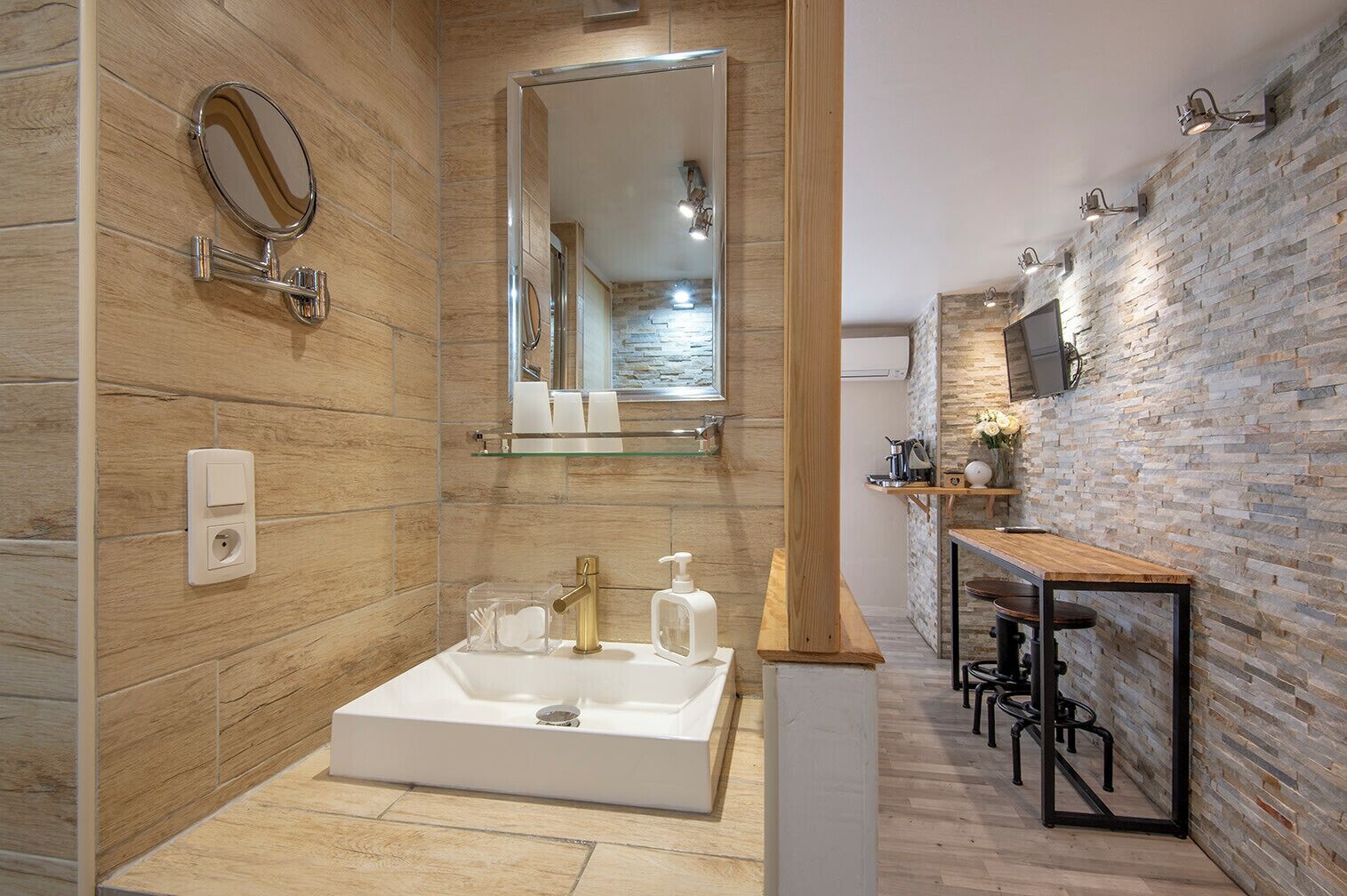 Un bany modern amb un mirall gran, un lavabo i una platja de dutxa.