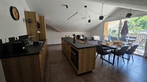 Una cucina moderna con isola centrale, mobili in legno e un'area pranzo con sedie e tavolo.