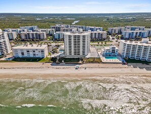 A coastal residential area with multiple high-rise buildings, a beach, and a swimming pool. - Seascape Towers 1123 (New Smyrna Beach)