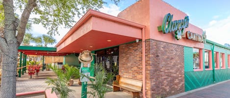 Un edificio con un letrero que dice 'Clancy's Cantina' y una estructura con forma de campana en su fachada.