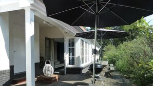 A covered outdoor area with a grill, a lantern, and a wooden deck. - Large Coastal Stay in Dishoek (Koudekerke)