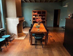 Ein Essbereich mit Holztisch, Stühlen, Kamin und Bücherregal.