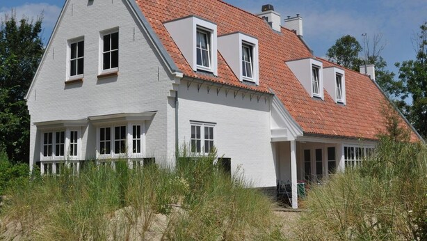 A two-story house with a red-tiled roof, white exterior walls, and multiple windows. - Large Coastal Stay in Dishoek (Koudekerke)
