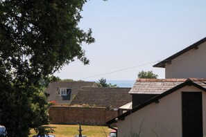 A residential area with houses, a lawn, and a view of the sea. - Gorway Cottage (Teignmouth)