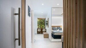Ein modernes Schlafzimmer mit Bett, Nachttisch und Blick ins Freie.