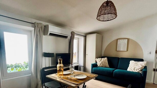 Ett modernt vardagsrum med en matplats, en soffa och en hängande lampa.