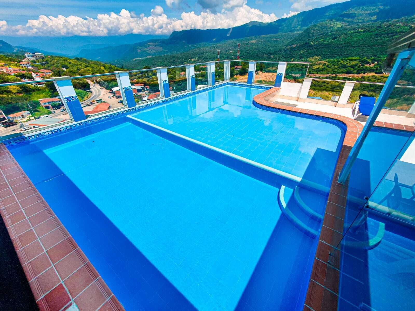 A large outdoor swimming pool with a view of a mountainous landscape.