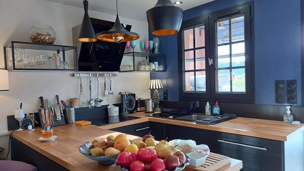 A modern kitchen with a central island, pendant lights, and a large window. - Provençal cottage (Roquebrune-sur-Argens)