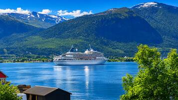A cruise ship on a calm lake with mountains in the background.