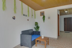 A room with a grey sofa, a wooden table, and a potted plant. - Maiata Beach 3 (Madeira)