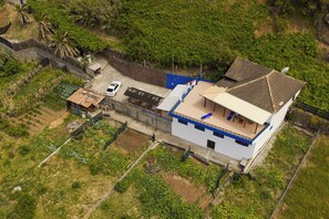 A two-story building with a flat roof, a balcony, and a car parked in front. - Maiata Beach 3 (Madeira)