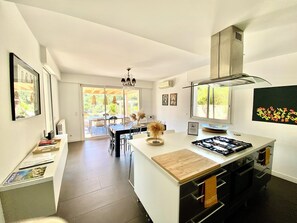 A modern kitchen with a central island, a dining area with a view, and a large window. - VillaSerenita Heated Pool, Jacuzzi, Ping Pong (ALATA)