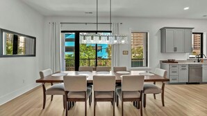 A modern dining area with a large table, chairs, and a chandelier. - Sleeps 28-Blue Whale-Pool-12 Bedrooms & 4 Kitchens (North Myrtle Beach)