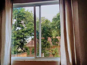 Una ventana con vistas a árboles y edificios.