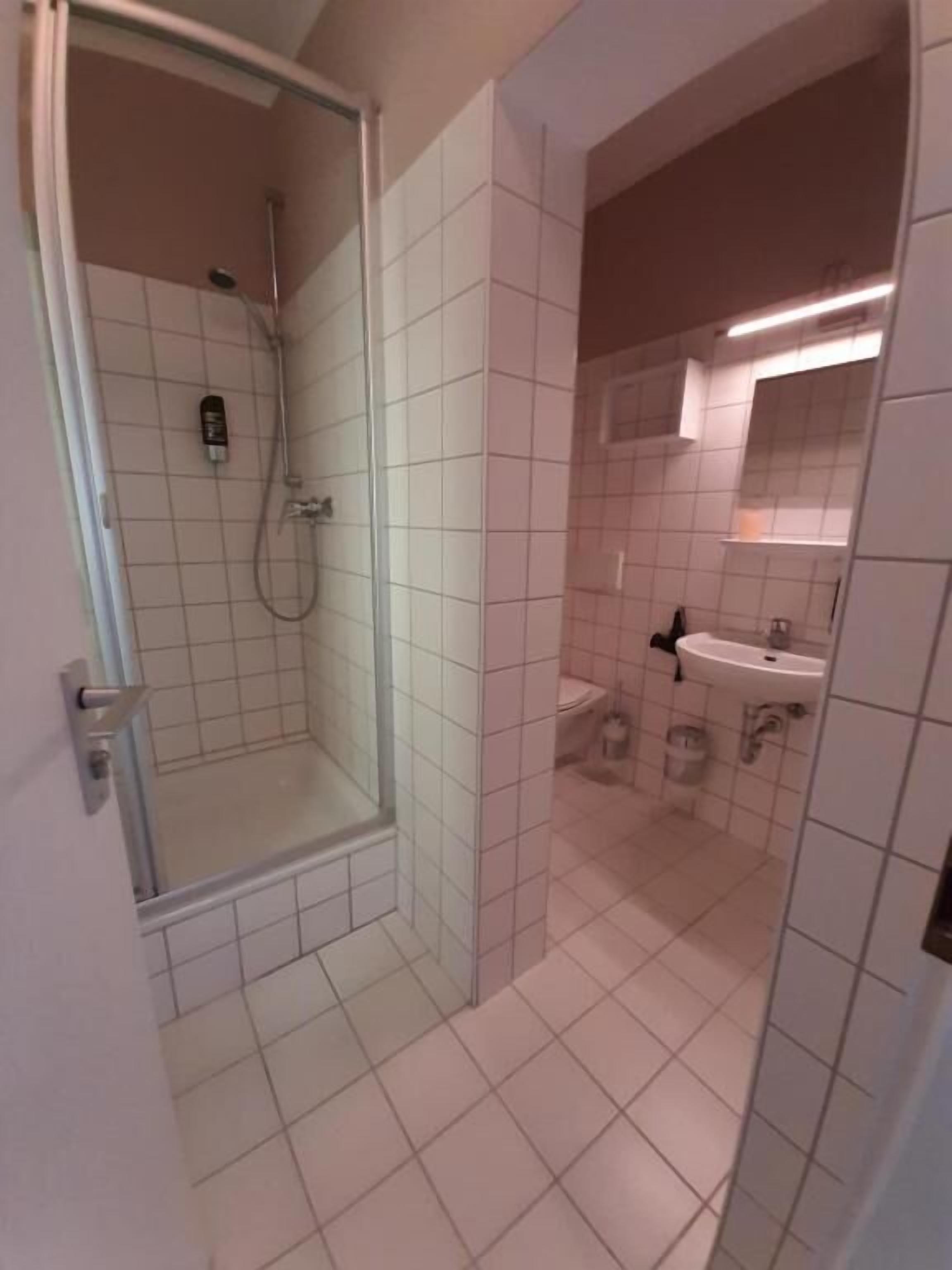 A bathroom with a shower, toilet, and sink.