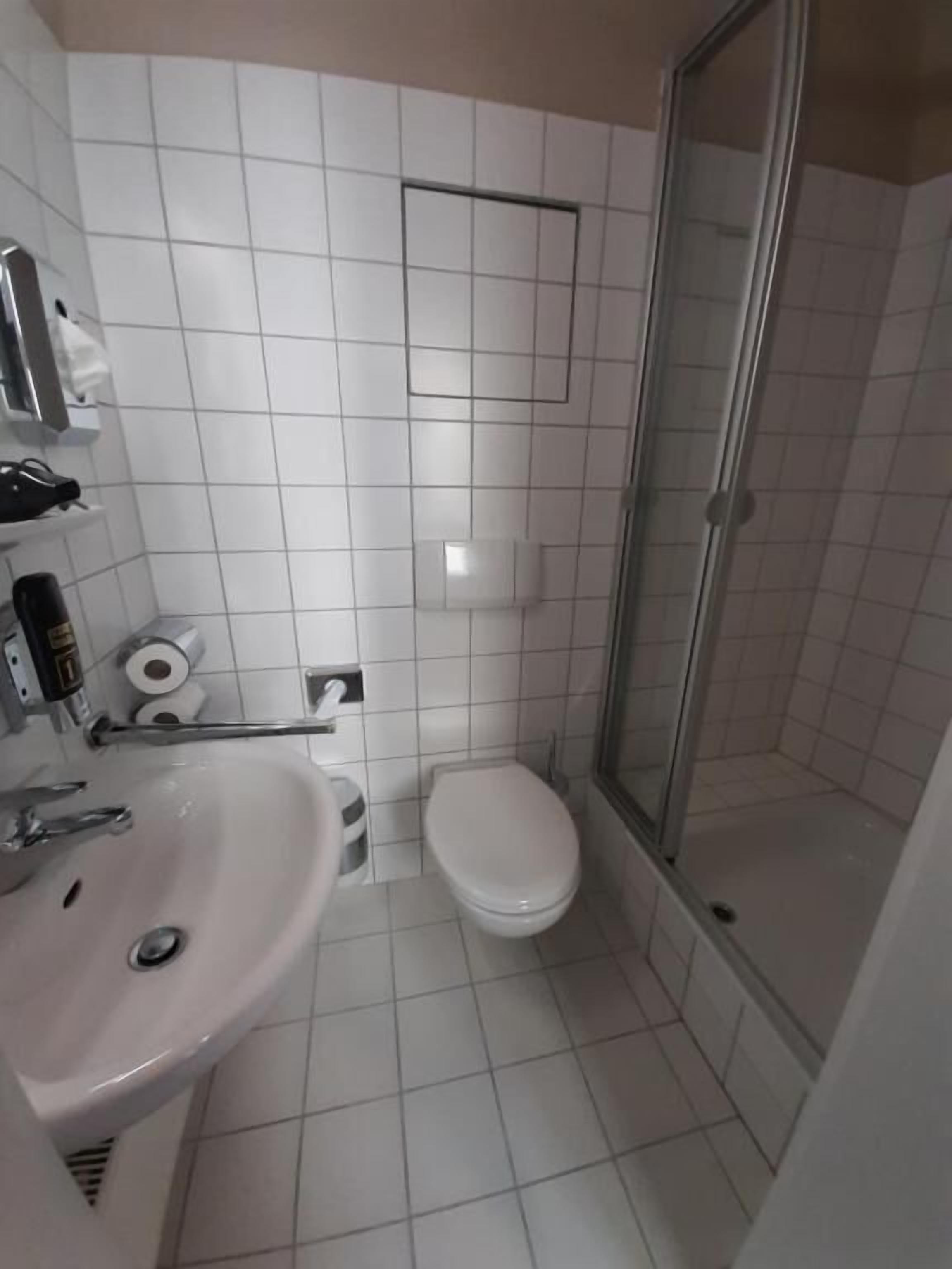 A bathroom with a sink, toilet, and shower.