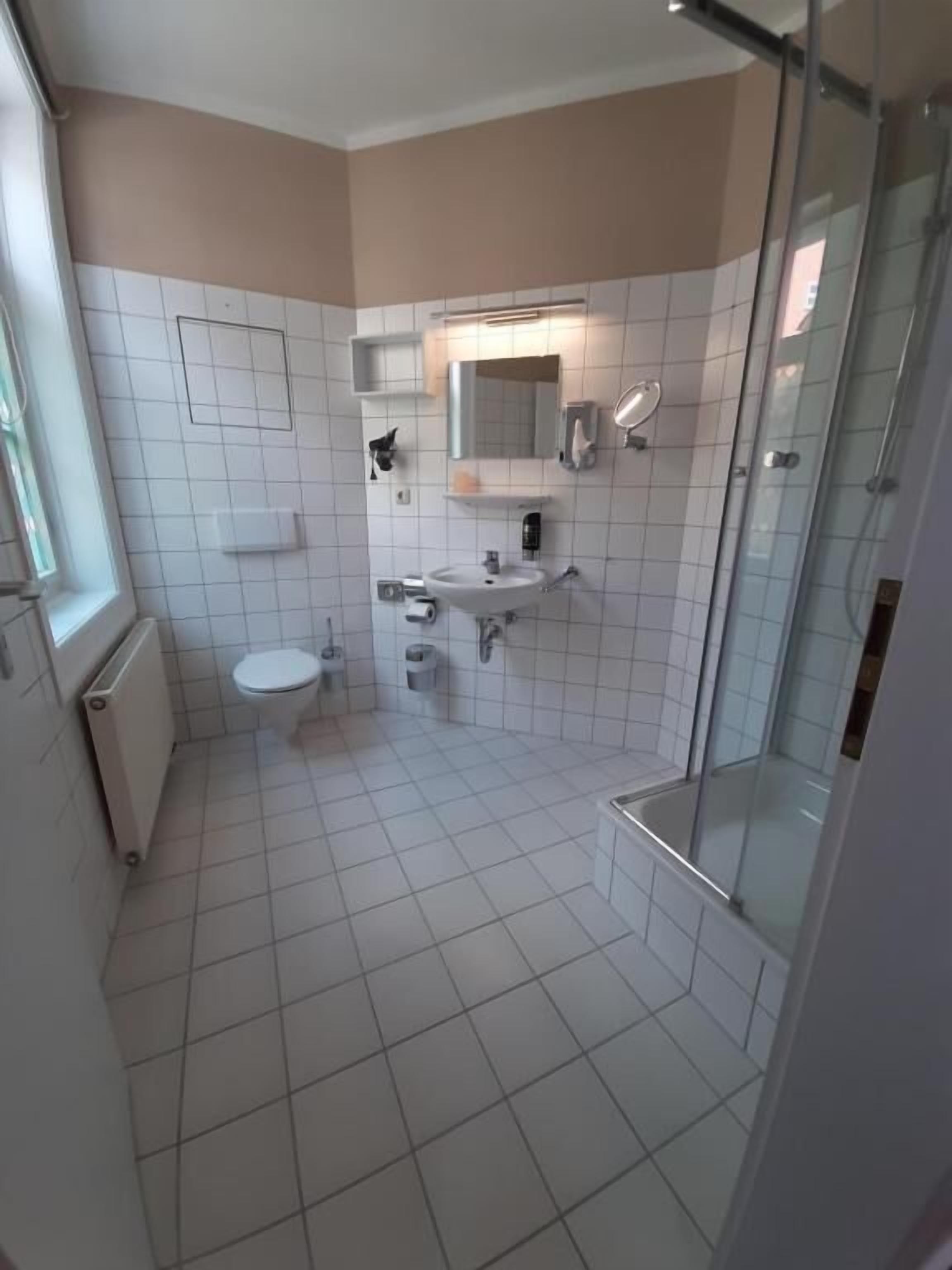 Un baño con inodoro, lavabo y cabina de ducha de vidrio.
