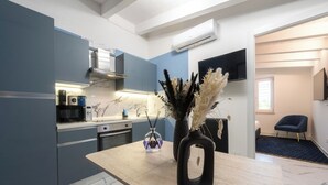 A modern kitchen with a marble countertop, a built-in stove, and a wall-mounted TV. - Just Relax Home (Sant'Angelo Romano)