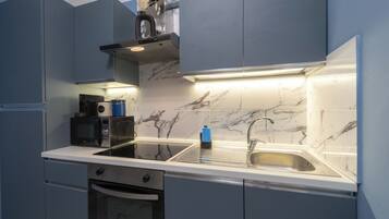 Una cocina moderna con horno integrado, microondas y pileta de acero inoxidable.