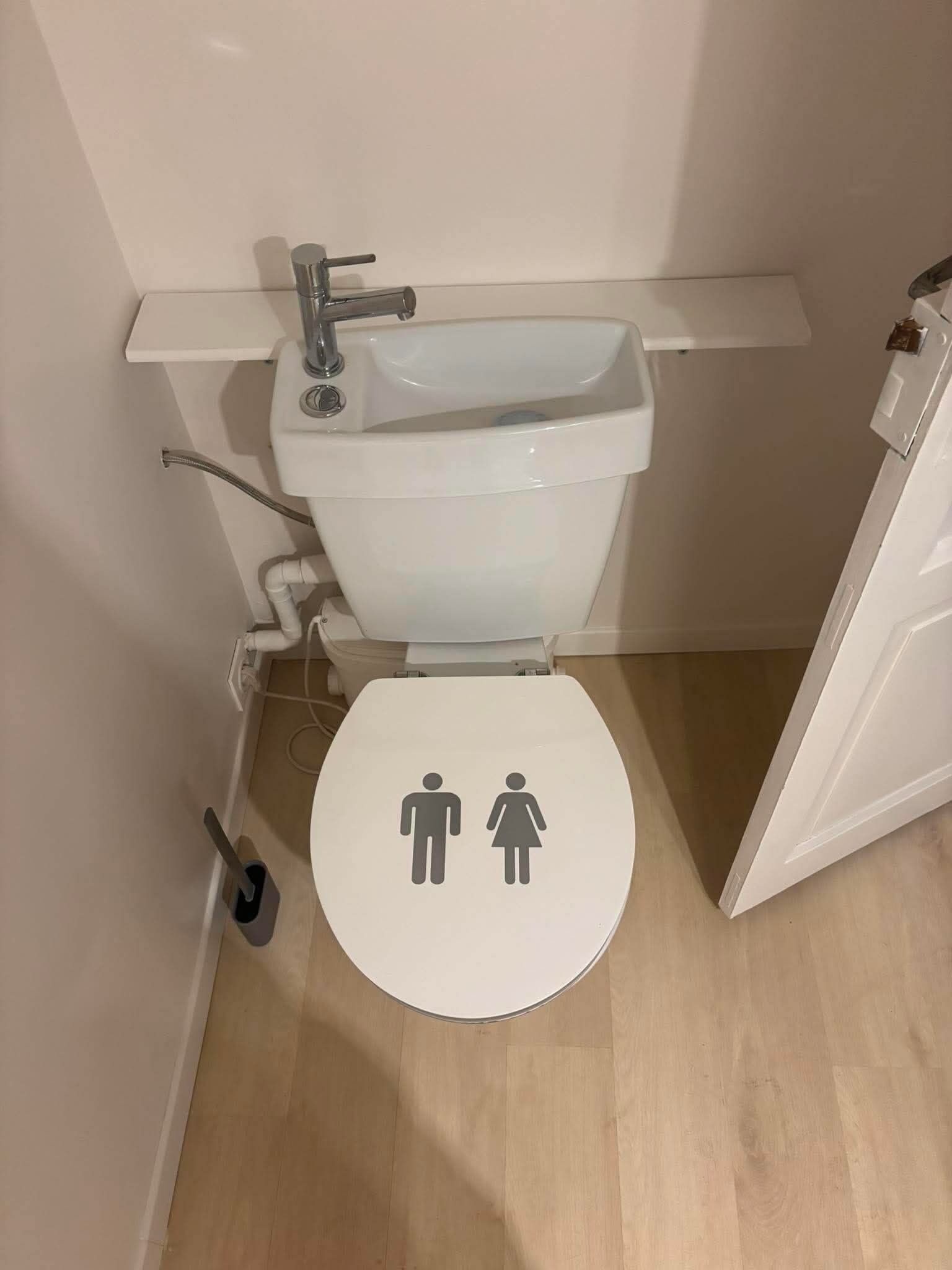 A small bathroom with a white toilet, a sink, and a bidet.