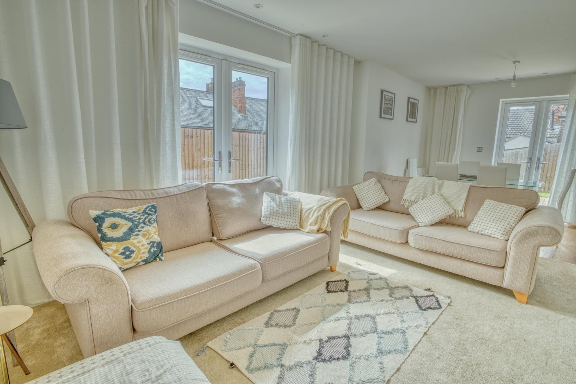 A living room with two sofas, a coffee table, and a patterned rug.