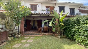 Una casa amb un patí, un jardí petit i una tanca de fusta.