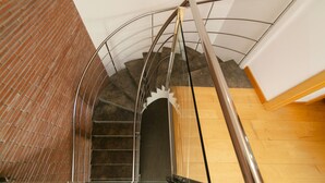 Eine Wendeltreppe mit Metallgeländern und einer Backsteinwand.