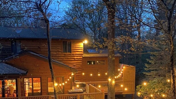 A log cabin with a deck, outdoor seating, and a fire pit. - Lake Harmony Luxury Escape,  Lake Access, Near Big Boulder, Sleeps 12 (Lake Harmony)