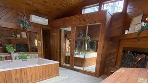 A wooden cabin interior with a kitchen area, a dining table, and a large window. - Lake Harmony Luxury Escape,  Lake Access, Near Big Boulder, Sleeps 12 (Lake Harmony)
