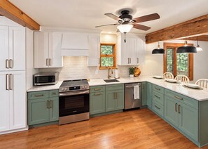 A kitchen with white cabinets, a microwave, an oven, and a ceiling fan. - Great Escape at Lake Harmony • 4BR • Beach Access • Game Room • Fire Pit (Lake Harmony)