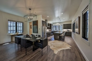A modern kitchen with a central island, dark wood flooring, and pendant lighting. - Brand New! I Downtown Winter Park w/Hot Tub (Winter Park)