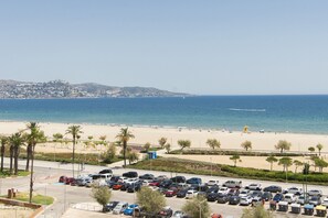 A parking lot with cars, a beach, and a clear sky. - WELCS STUDIO 393 EMP, Oceanfront (Empuriabrava)