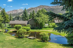 A residential area with houses, a pond, and mountains in the background. - Charming Snowcreek Meadow Unit w/ Views (Mammoth Lakes)