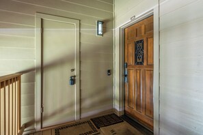 A hallway with a wooden door, a metal door, and a number sign above the door. - Charming Snowcreek Meadow Unit w/ Views (Mammoth Lakes)