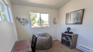 A room with a desk, bean bag, bookshelf, and a painting on the wall. - Fabulous 3-bedroom duplex in friendly Greeley (Greeley)