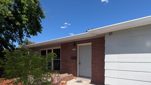 A two-story building with a brick facade, a white door, and a small porch area. - Fabulous 3-bedroom duplex in friendly Greeley (Greeley)