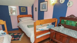 A bedroom with two wooden beds, a wooden dresser, and a small desk. - Dairy Cottage (Ventnor)