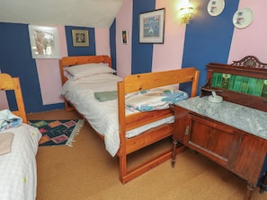 A bedroom with two wooden beds, a wooden dresser, and a small desk. - Dairy Cottage (Ventnor)