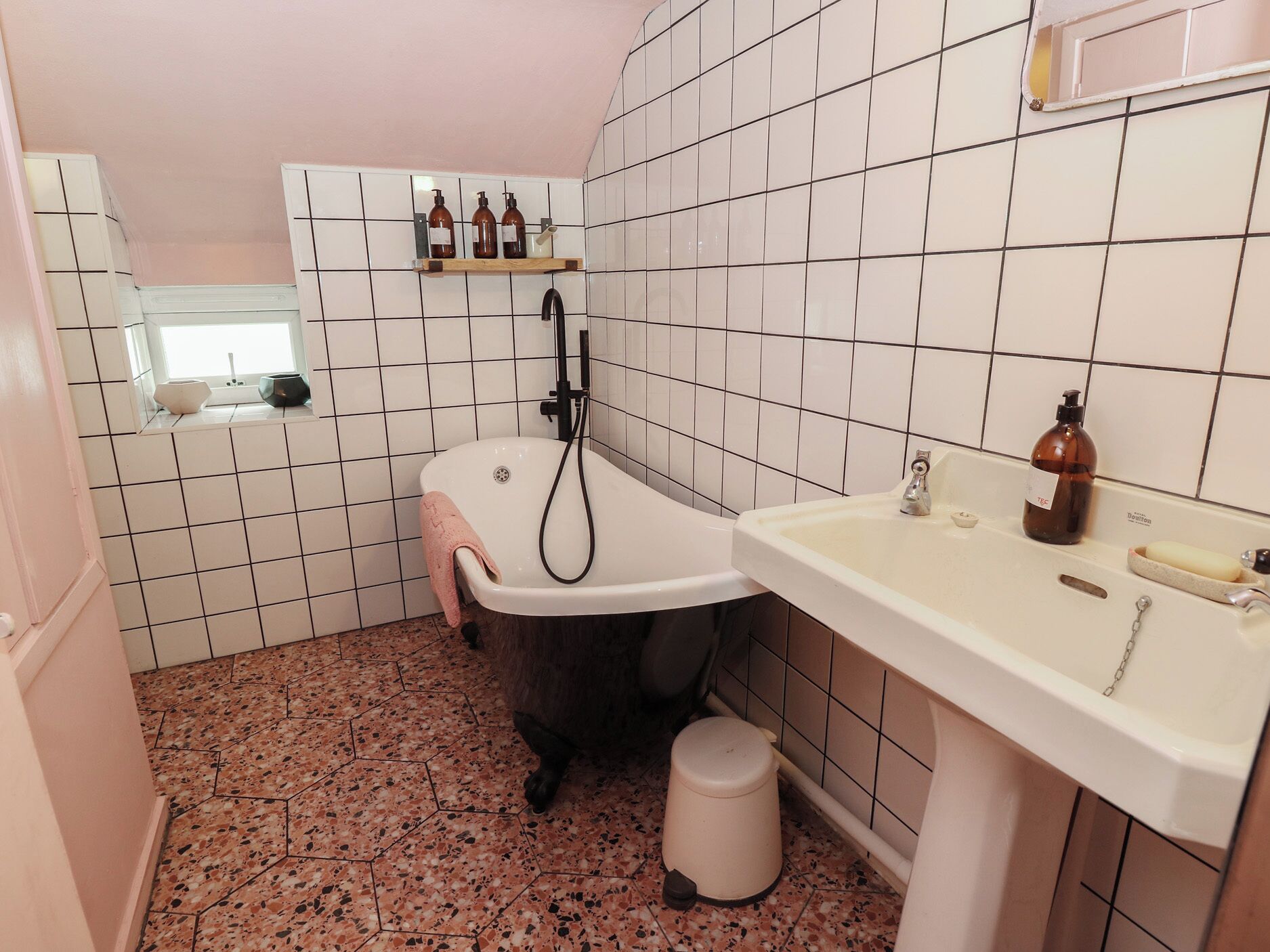 A bathroom with a bathtub, sink, and tiled walls.