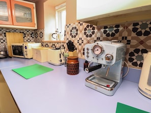 Una cocina con cafetera, tostadora y salpicadero decorado.