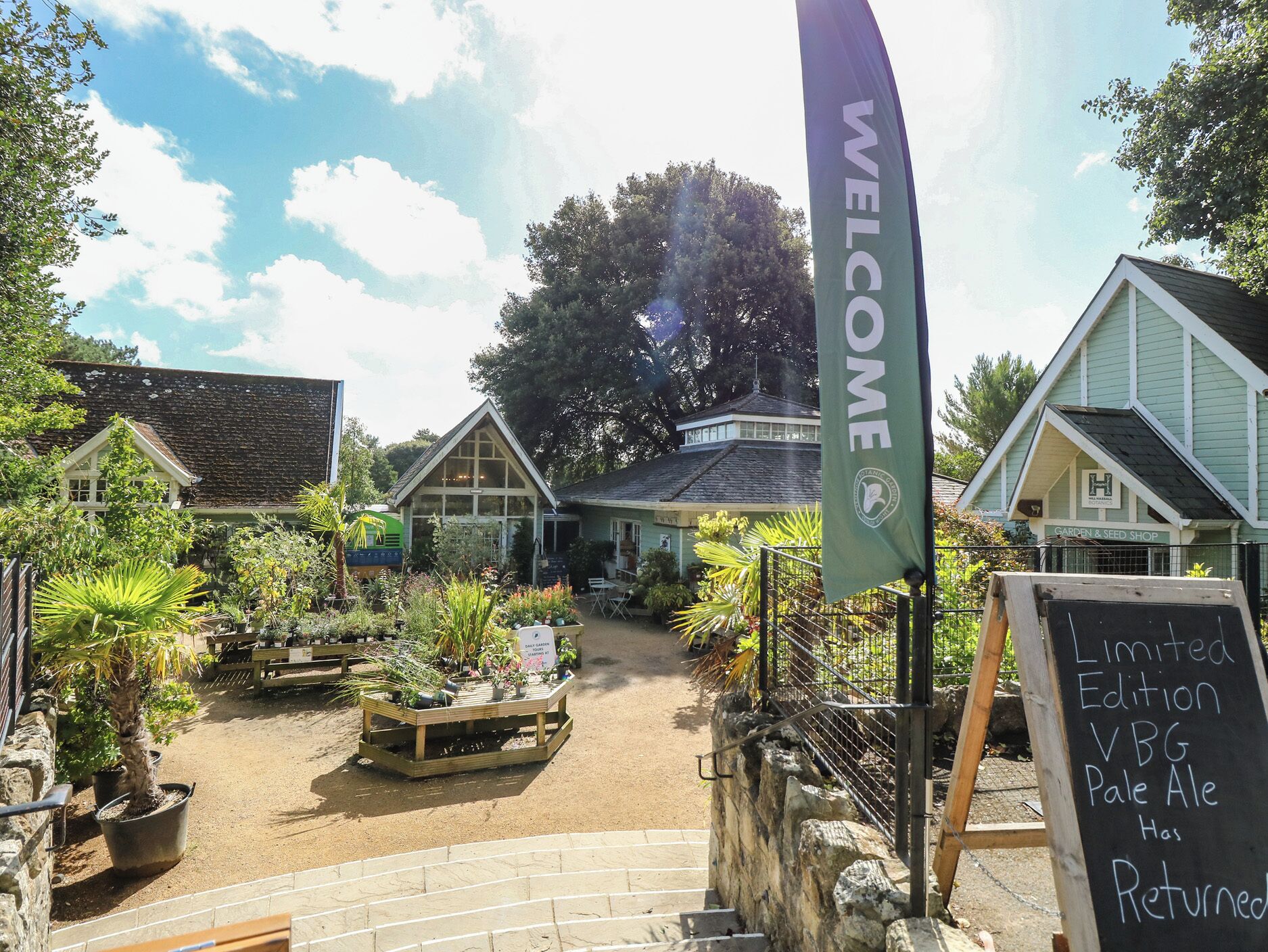 A garden center with a 'WELCOME' banner, a sign for 'Limited Edition VBG Pale Ale,' and a 'Garden & Seed Shop.'