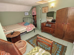 A bedroom with a bed, dresser, nightstand, and a large wardrobe. - Dairy Cottage (Ventnor)
