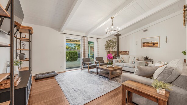 A spacious living room with a sofa, chairs, a coffee table, and a staircase.