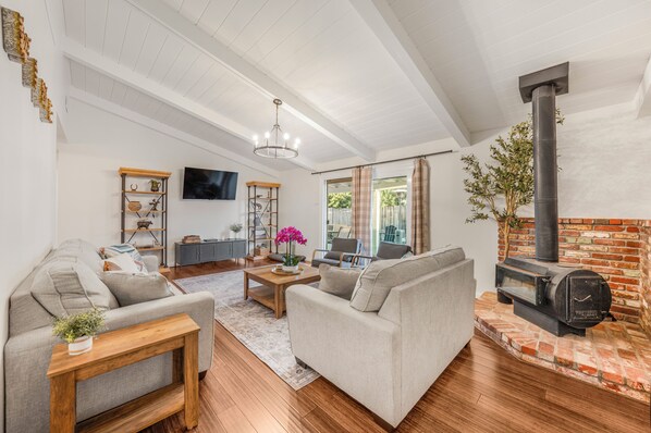 A living room with a fireplace, a sofa set, a coffee table, and a television.