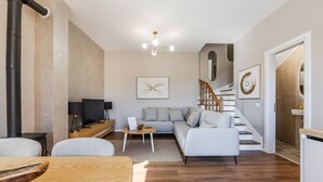 A modern living room with a sofa, coffee table, and a fireplace. - Villa Bora No 7 Belvedere Kor a (Qendër Bulgarec)