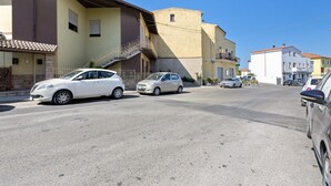 Vista de la calle con coches estacionados y edificios.